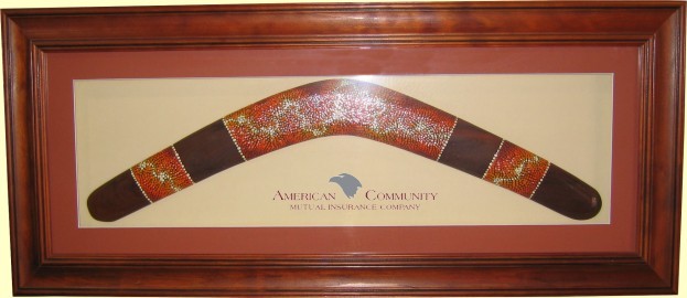 Framed Aboriginal dot art boomerang, 22 inch. Printed logo